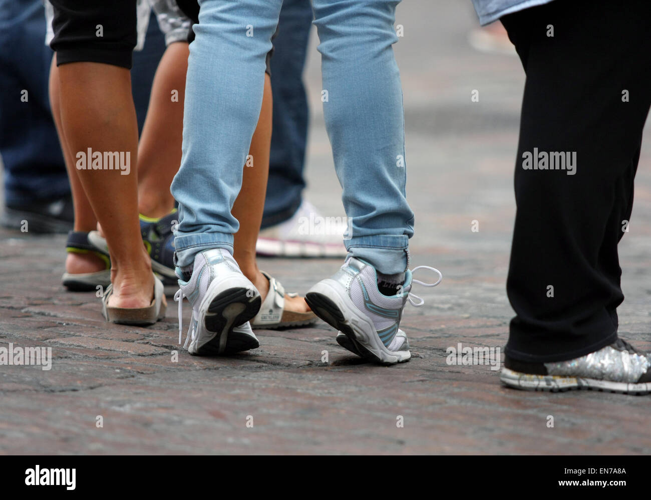 A view of pairs of legs - one person standing with their heels raised off the ground Stock Photo
