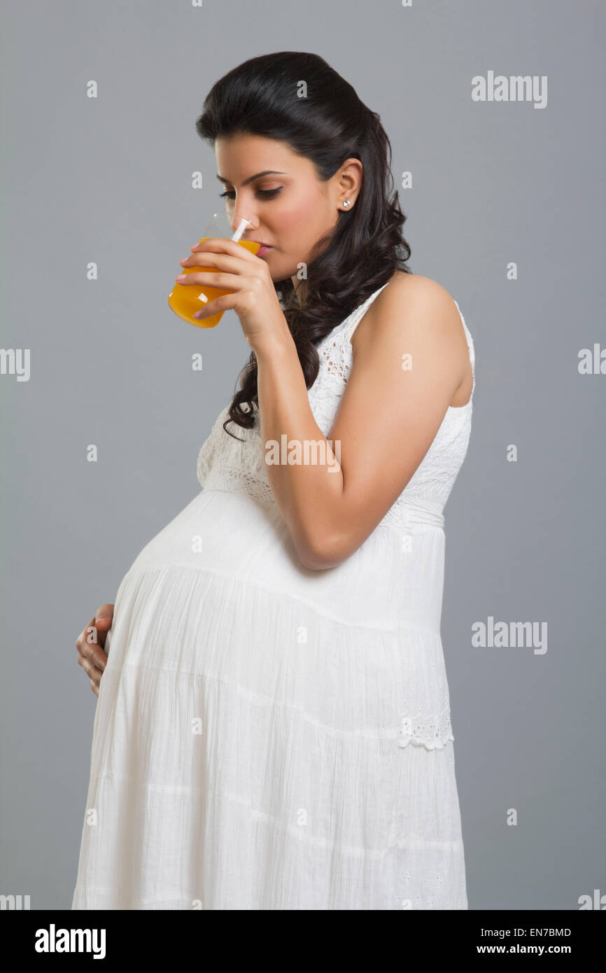 Pregnant woman drinking a glass of orange juice Stock Photo - Alamy