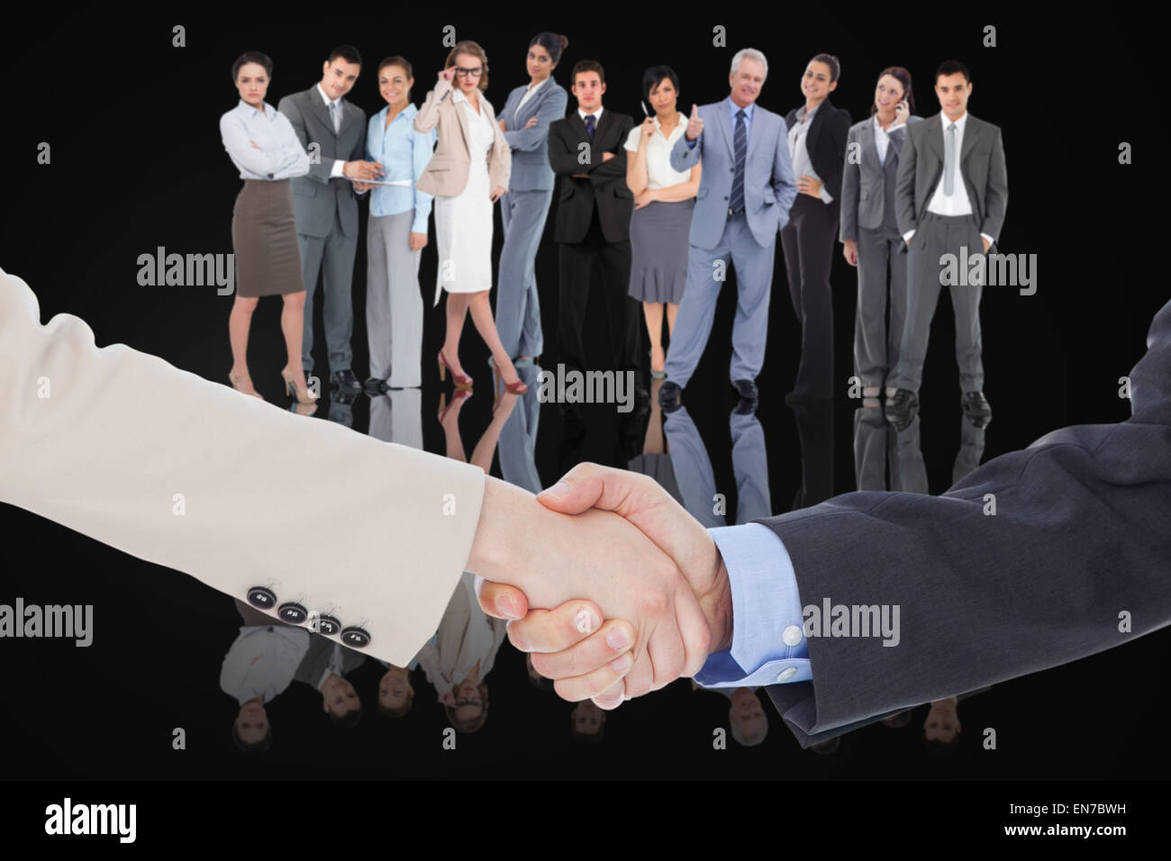 Composite image of smiling business people shaking hands while looking at the camera Stock Photo