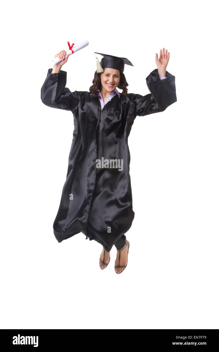Portrait of woman in graduation gown jumping Stock Photo - Alamy