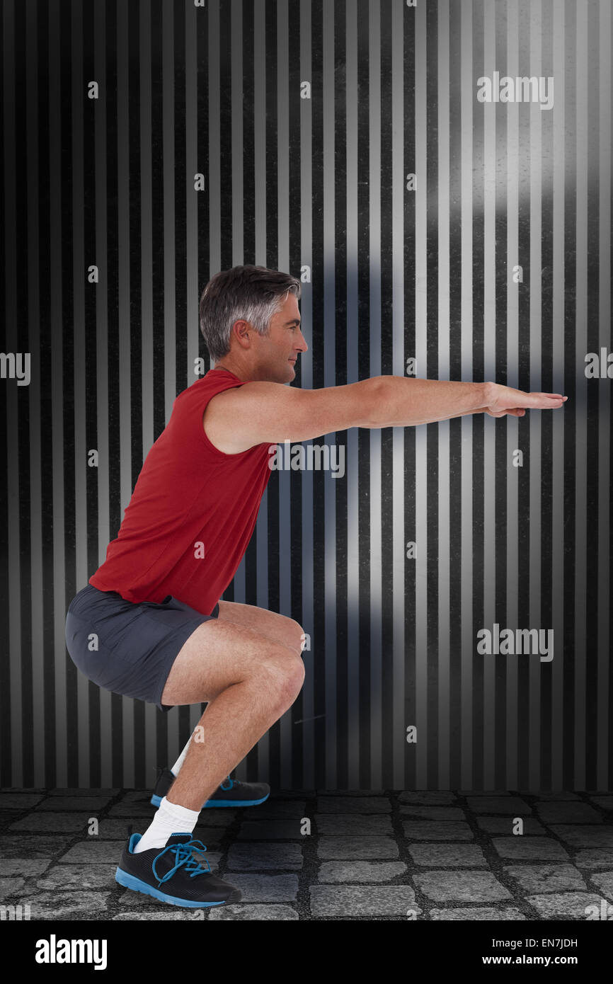 Composite image of fit man doing a squat Stock Photo