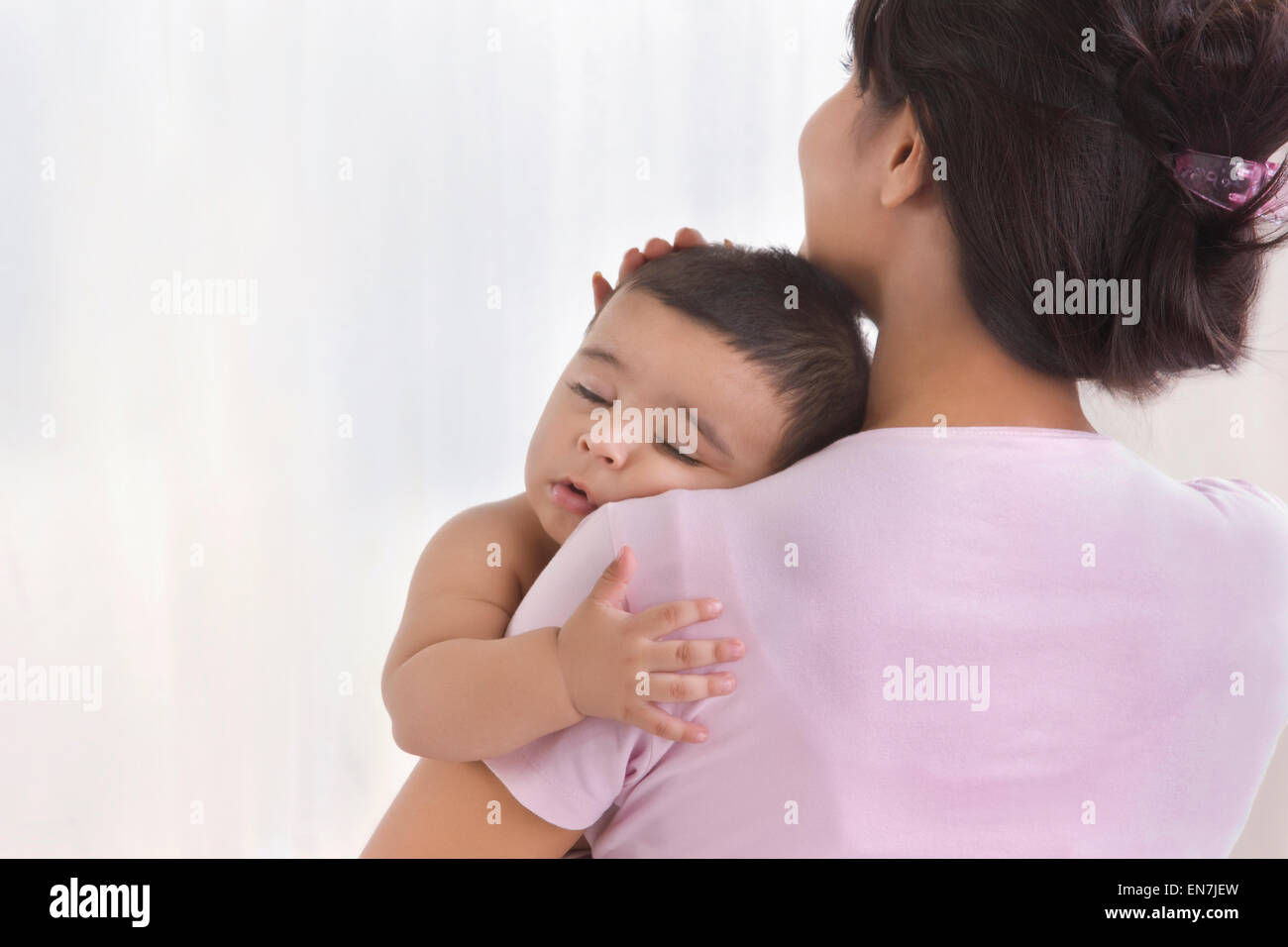 Baby sleeping in mothers arms Stock Photo Alamy