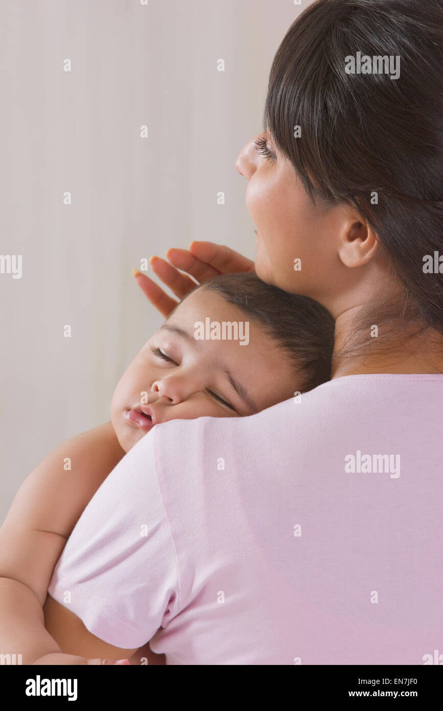 Baby sleeping in mothers arms Stock Photo Alamy