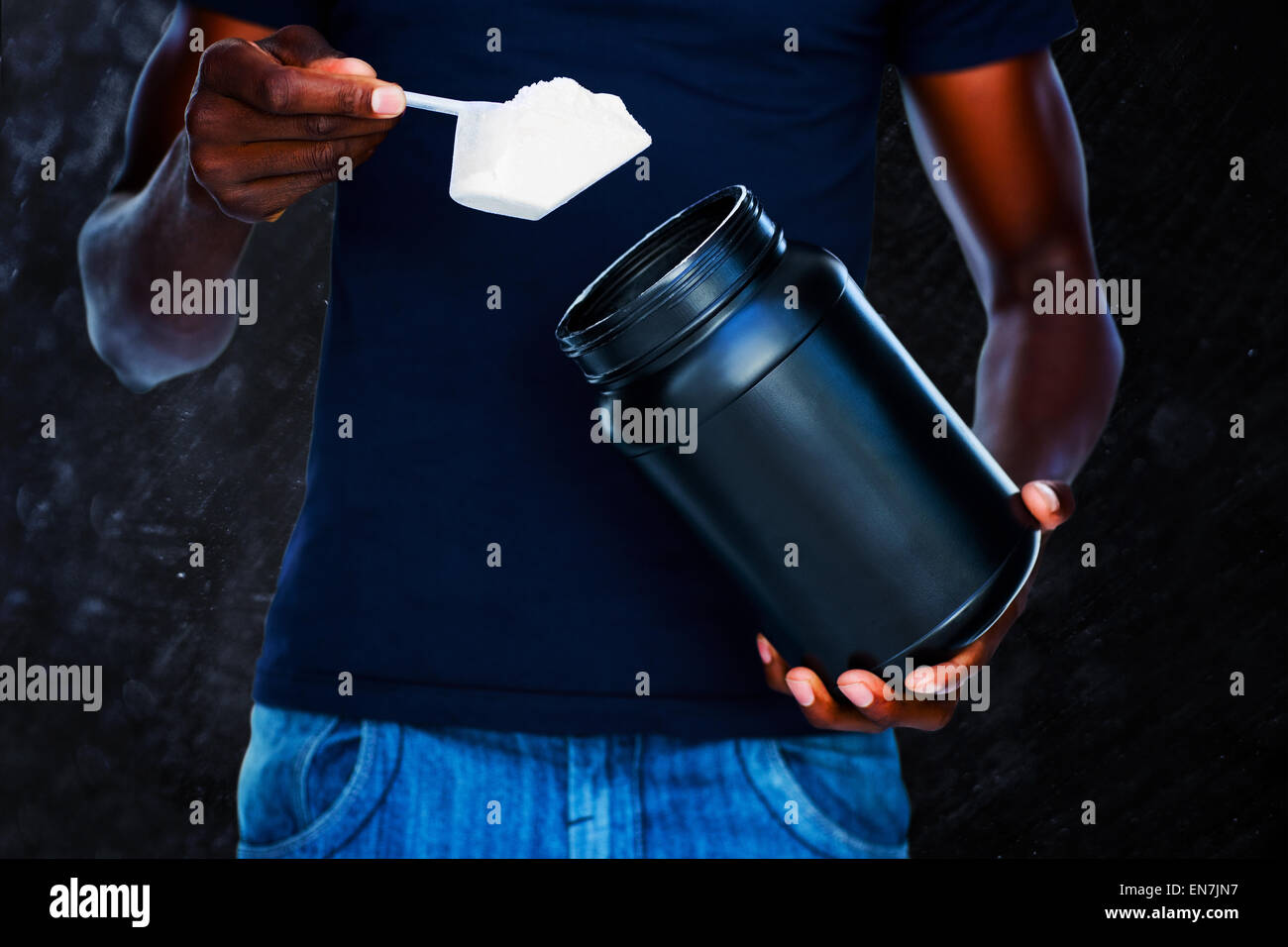 Composite image of mid section of man holding a scoop of protein mix Stock Photo