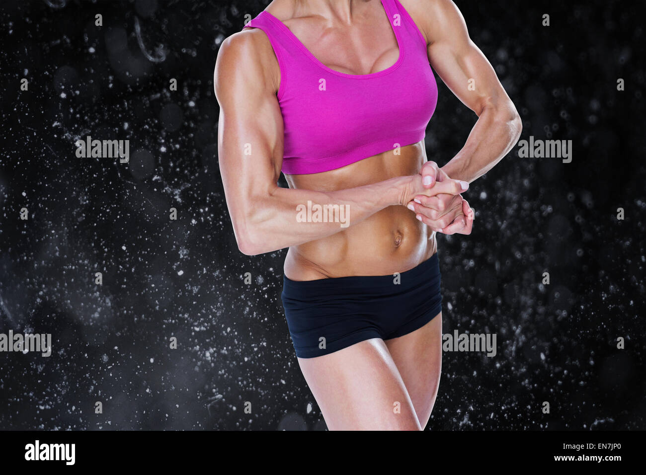 Composite image of female bodybuilder flexing in sports bra and shorts Stock Photo