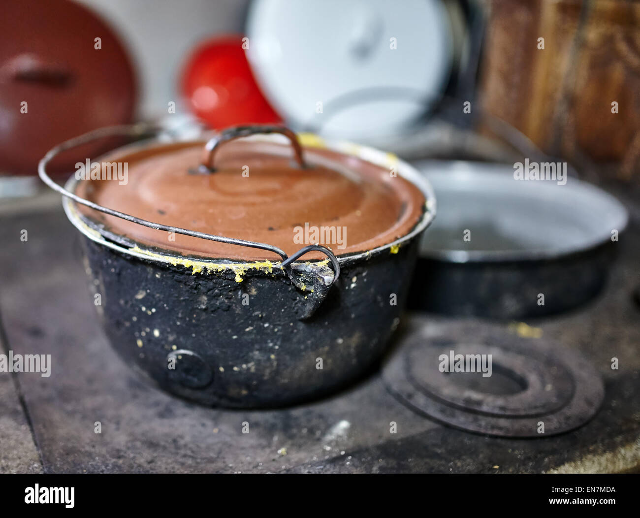 Preparing polenta on ironcast stove with firewood, traditional food