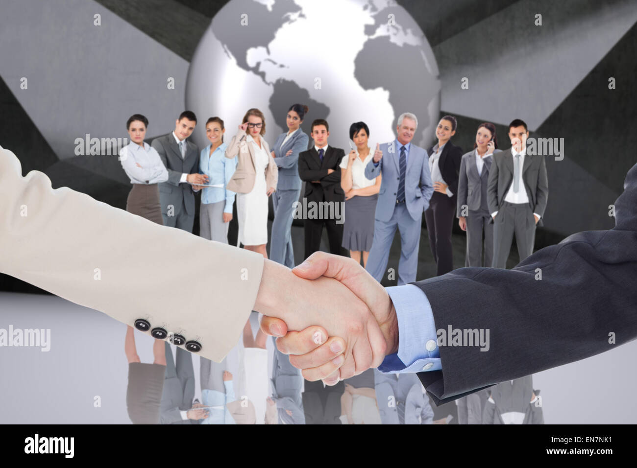Composite image of smiling business people shaking hands while looking at the camera Stock Photo