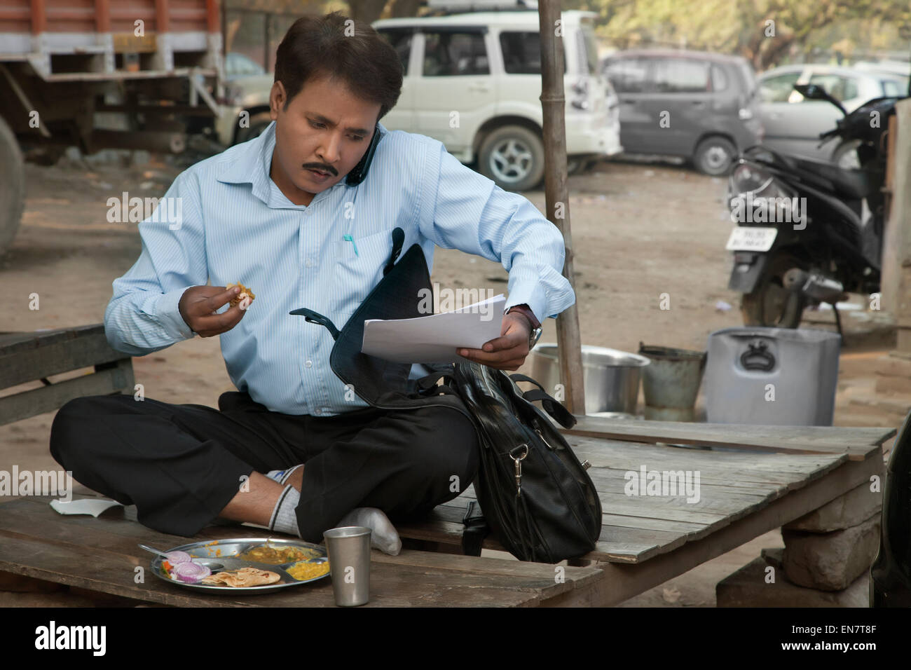 Salesman having lunch and using cell phone Stock Photo