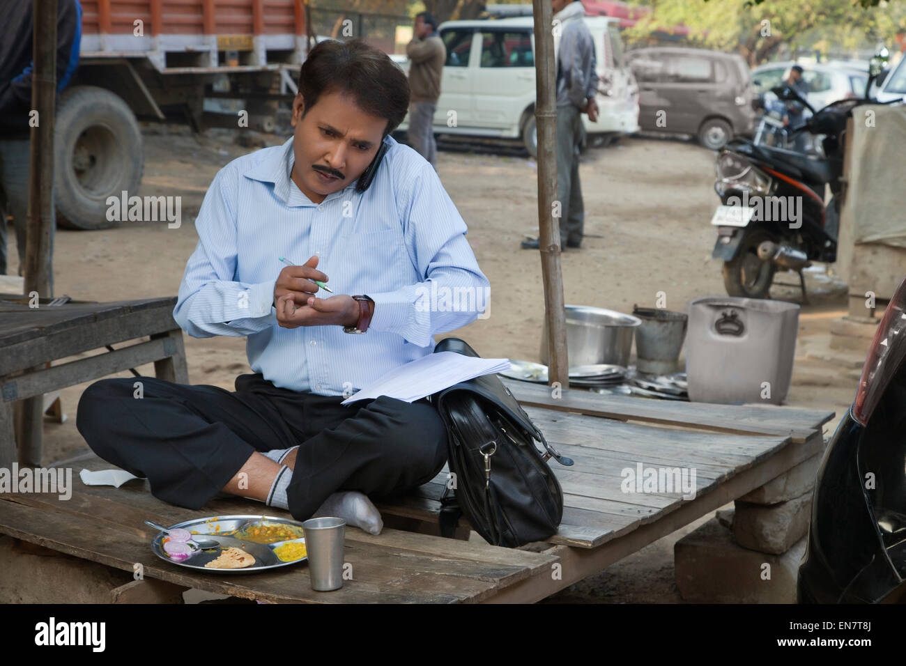 Salesman talking on a mobile phone and writing on paper Stock Photo