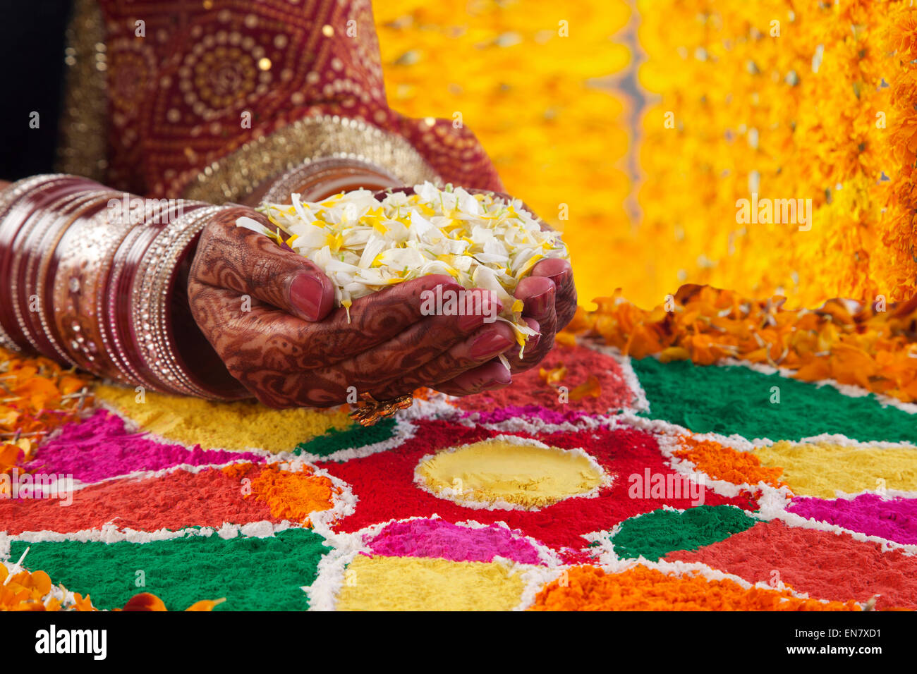 Closeup of bride performing marriage rituals with marigold petals Stock Photo