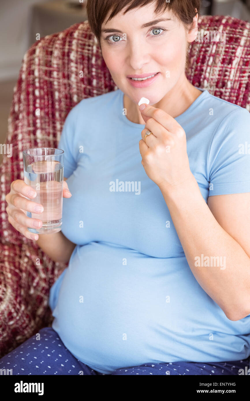 Pregnant woman taking a vitamin tablet Stock Photo Alamy