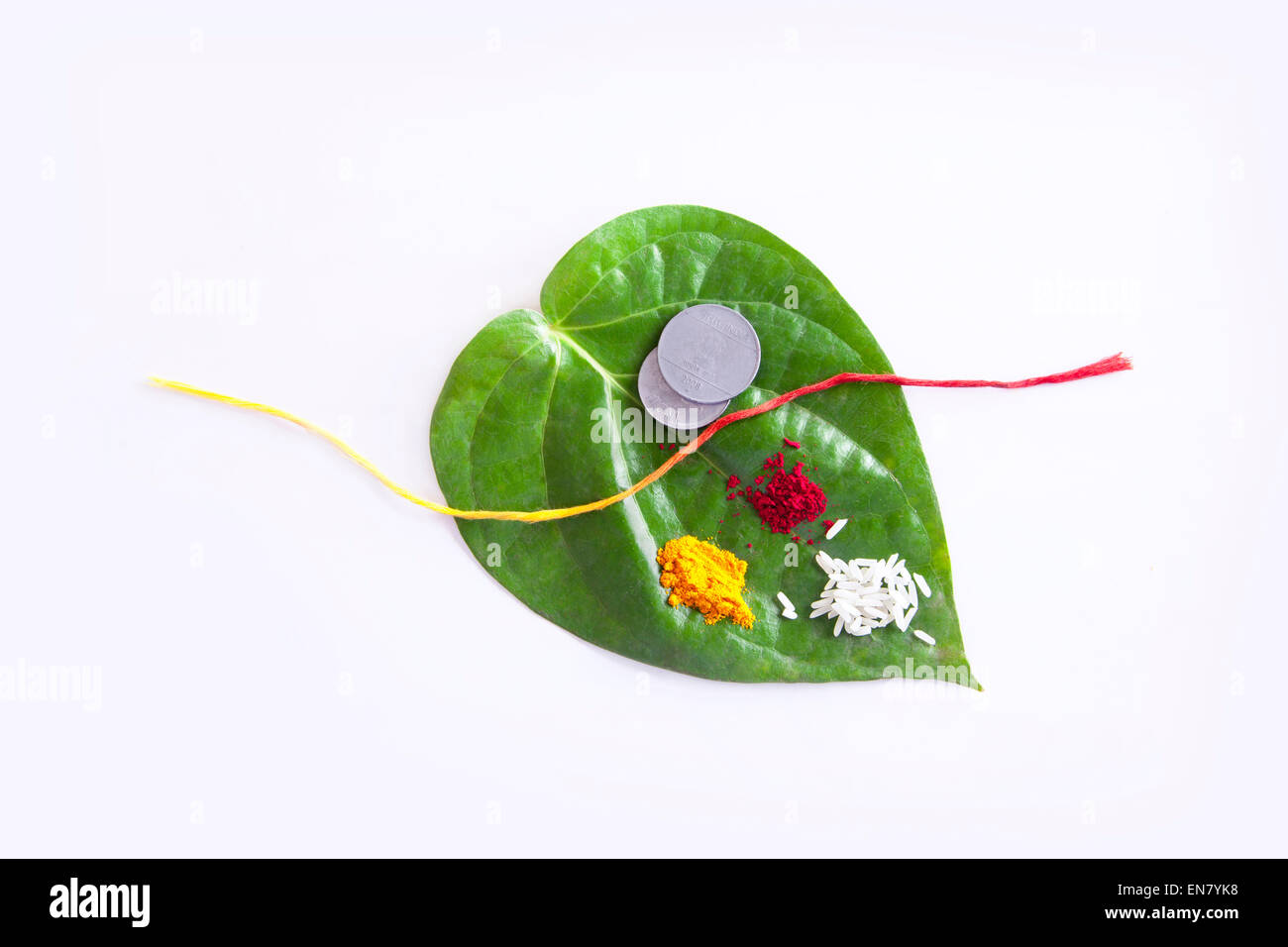 Betel Leaf with Rice,Coins,Red thread,Kumkum and Turmeric Stock Photo