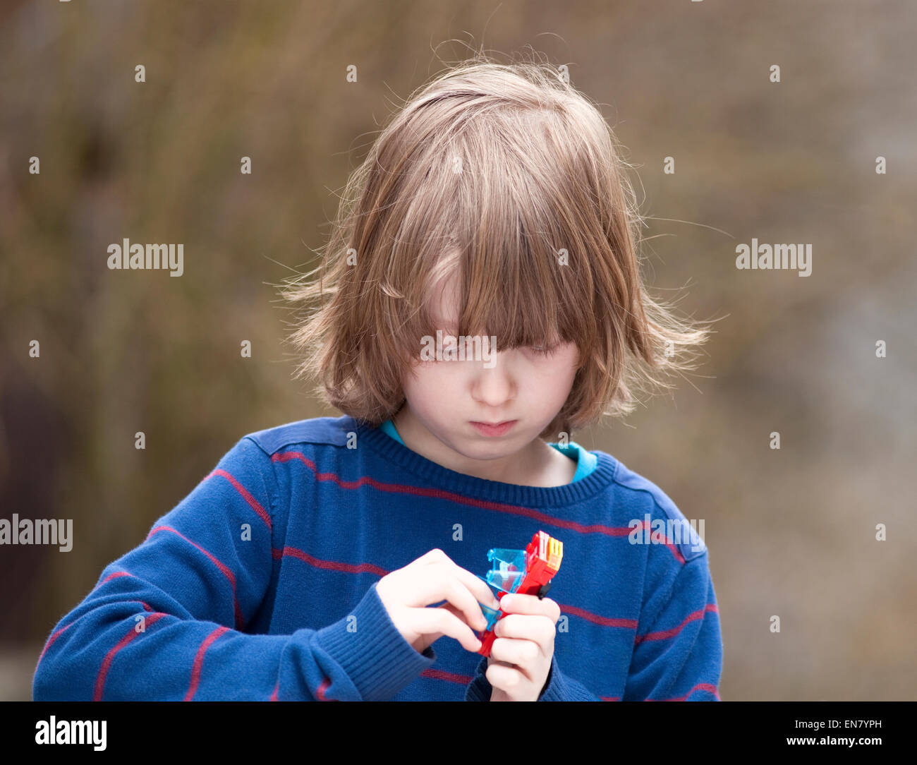Boy Putting Together his Assembling Toys Outdoors Stock Photo