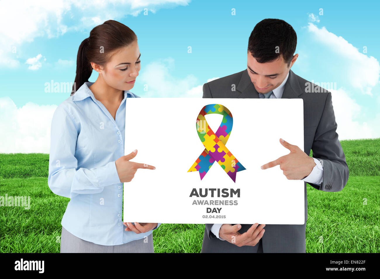 Composite image of business partners pointing at sign they are presenting Stock Photo