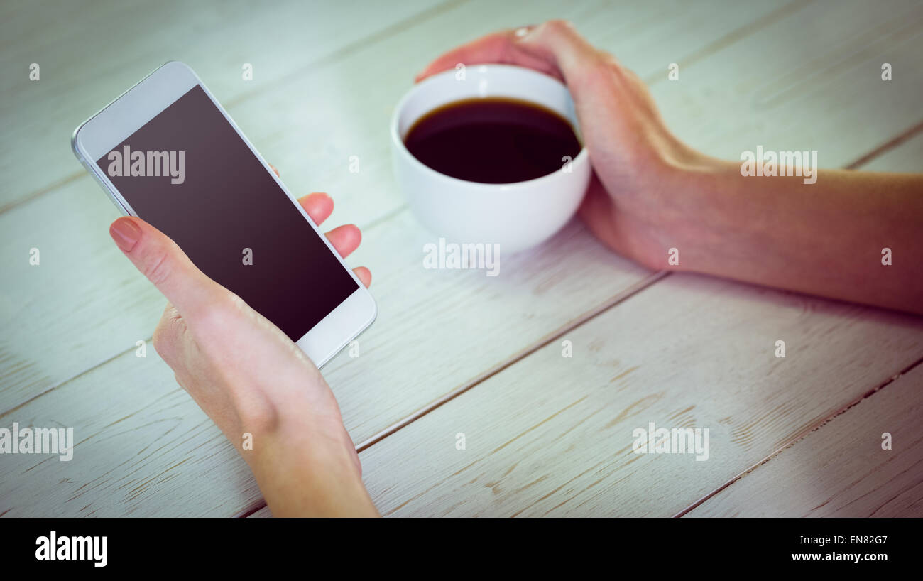 Woman using her smartphone with coffee Stock Photo
