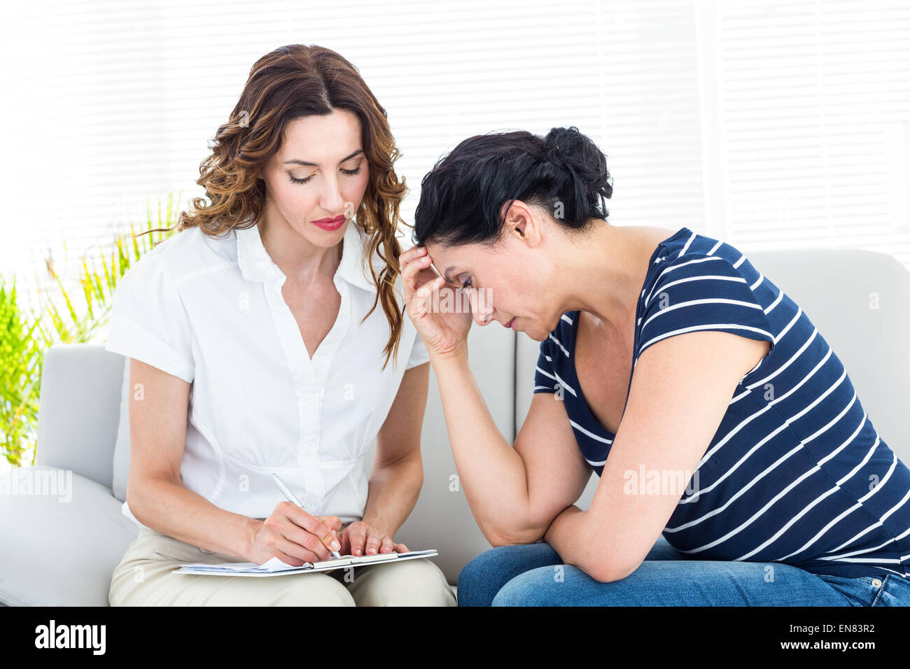 Depressed woman talking with her therapist Stock Photo Alamy