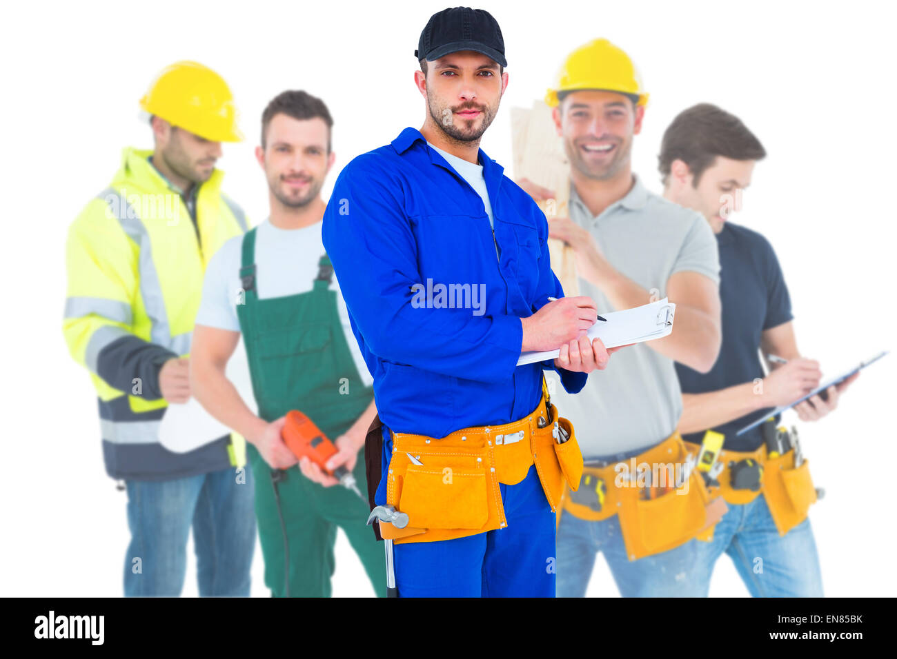 Composite image of handyman in blue overall writing on clipboard Stock Photo