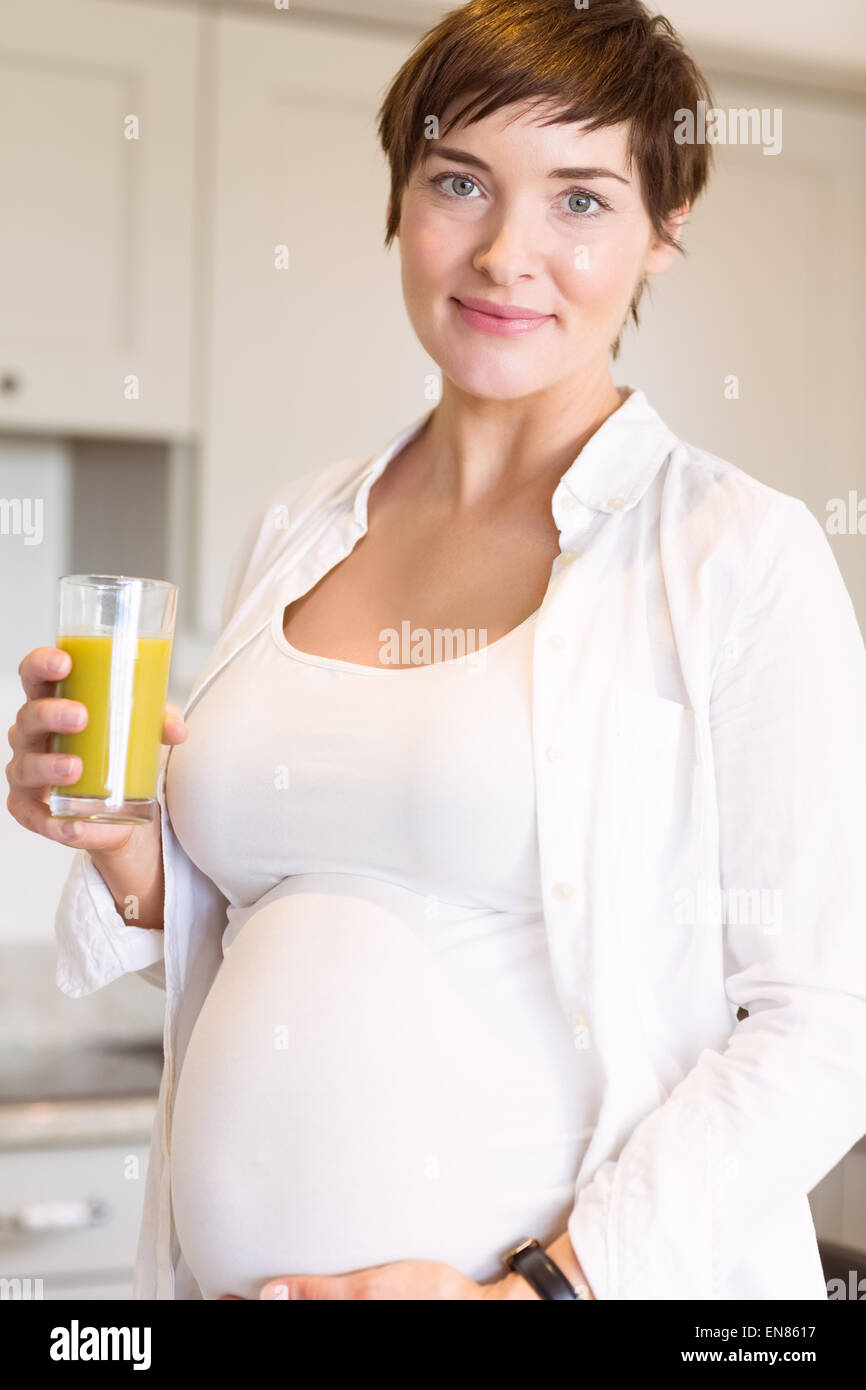 Pregnant woman having a glass of orange juice Stock Photo - Alamy