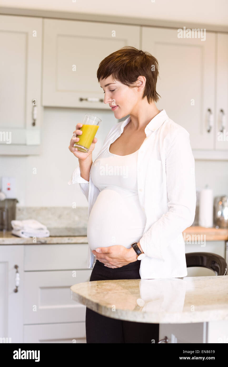Pregnant woman having a glass of orange juice Stock Photo - Alamy