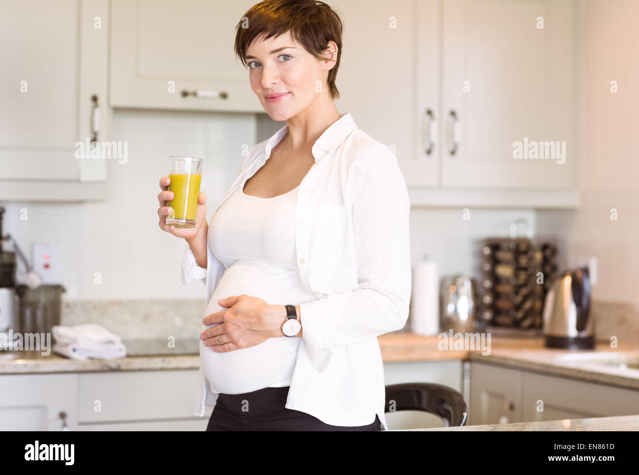 Pregnant woman having a glass of orange juice Stock Photo - Alamy