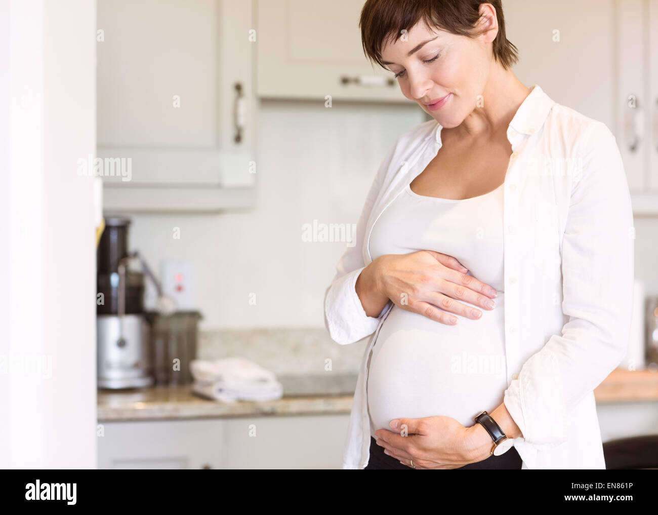 Pregnant woman holding her bump Stock Photo - Alamy