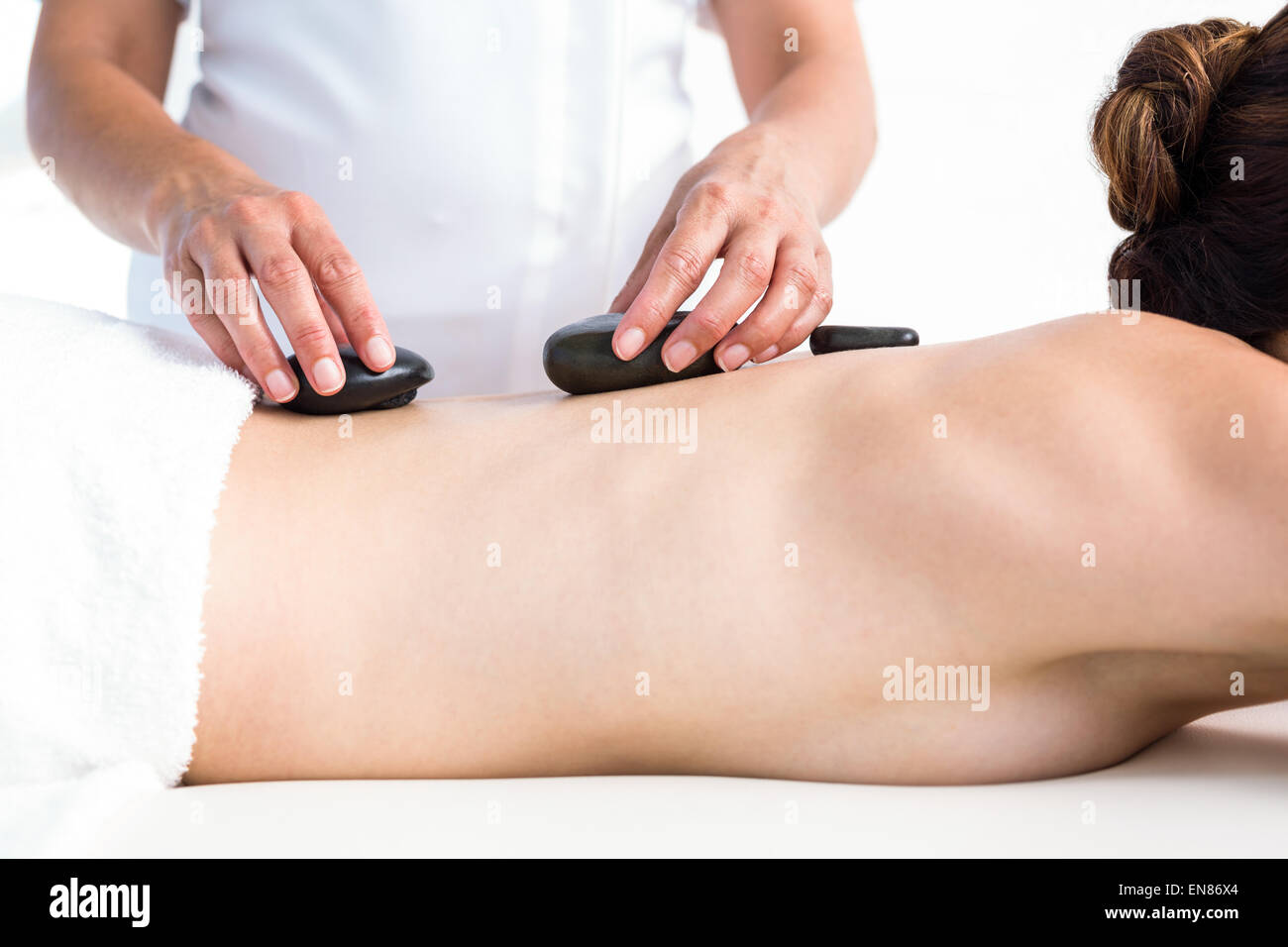 Brunette getting hot stone massage Stock Photo