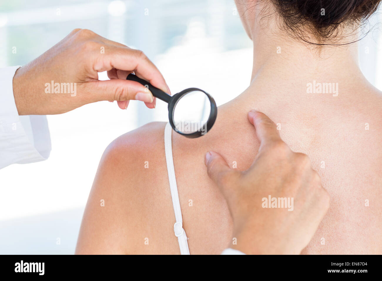 Doctor examining patient with magnifying glass Stock Photo