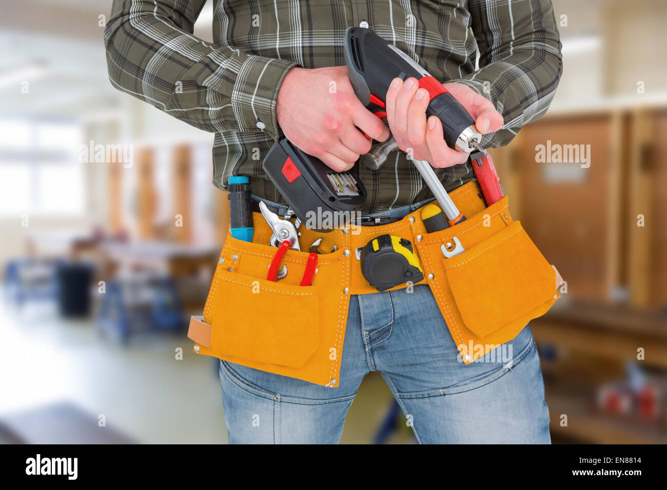 Composite image of manual worker holding gloves and hammer power drill Stock Photo