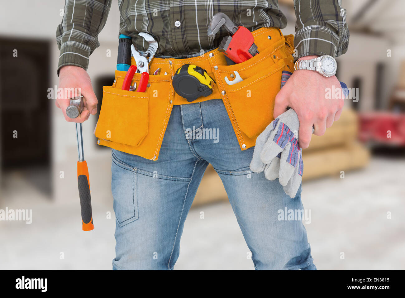 Composite image of manual worker holding gloves and hammer Stock Photo