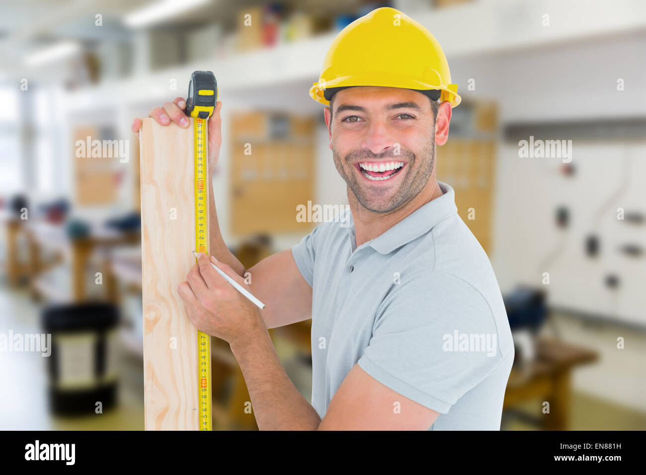 Composite image of construction worker using measure tape to mark on plank Stock Photo