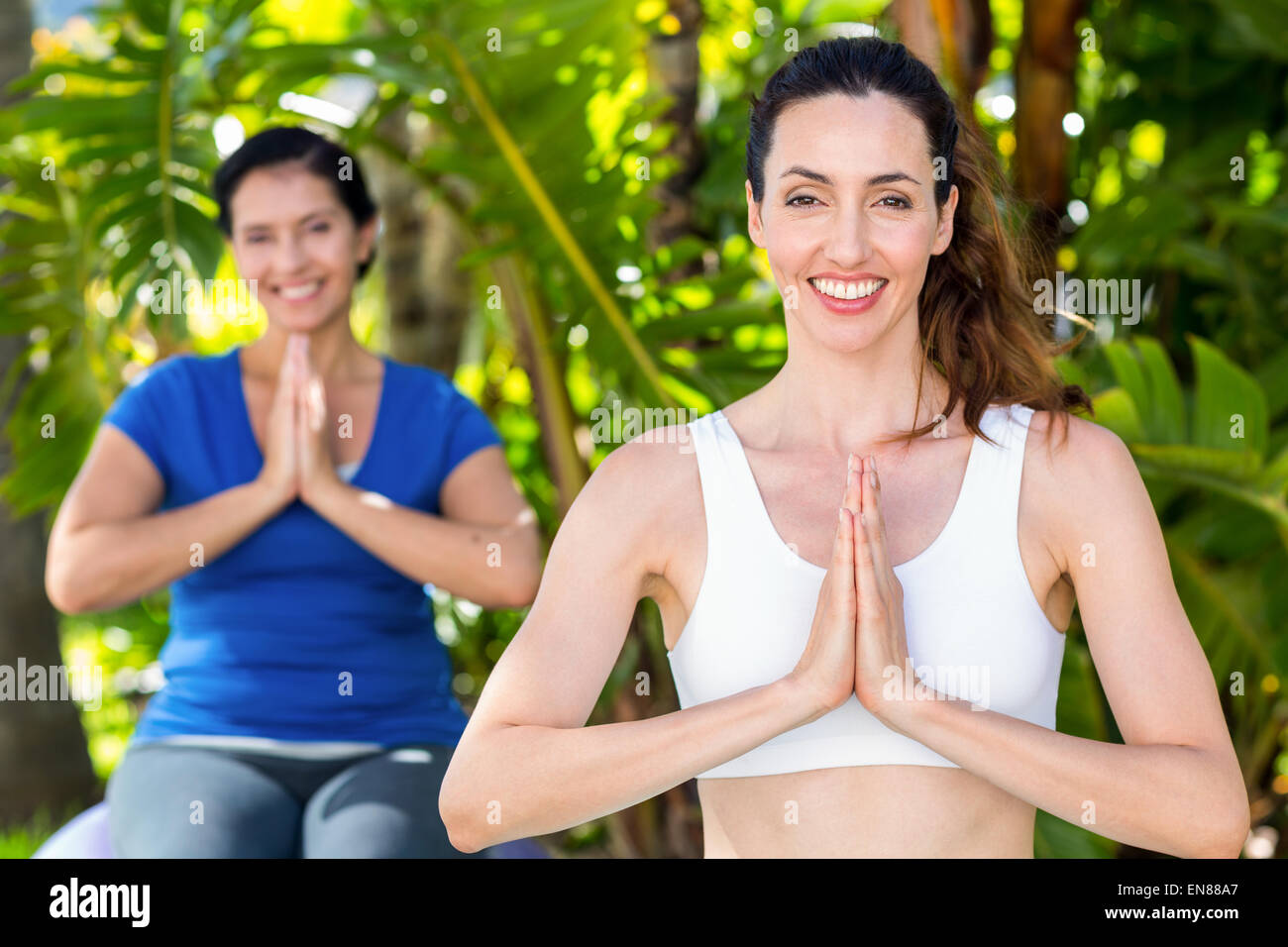 Relaxed woman and her trainer doing yoga Stock Photo