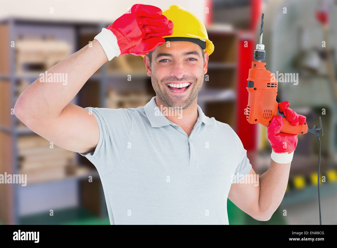 Composite image of smiling manual worker holding drill machine Stock Photo