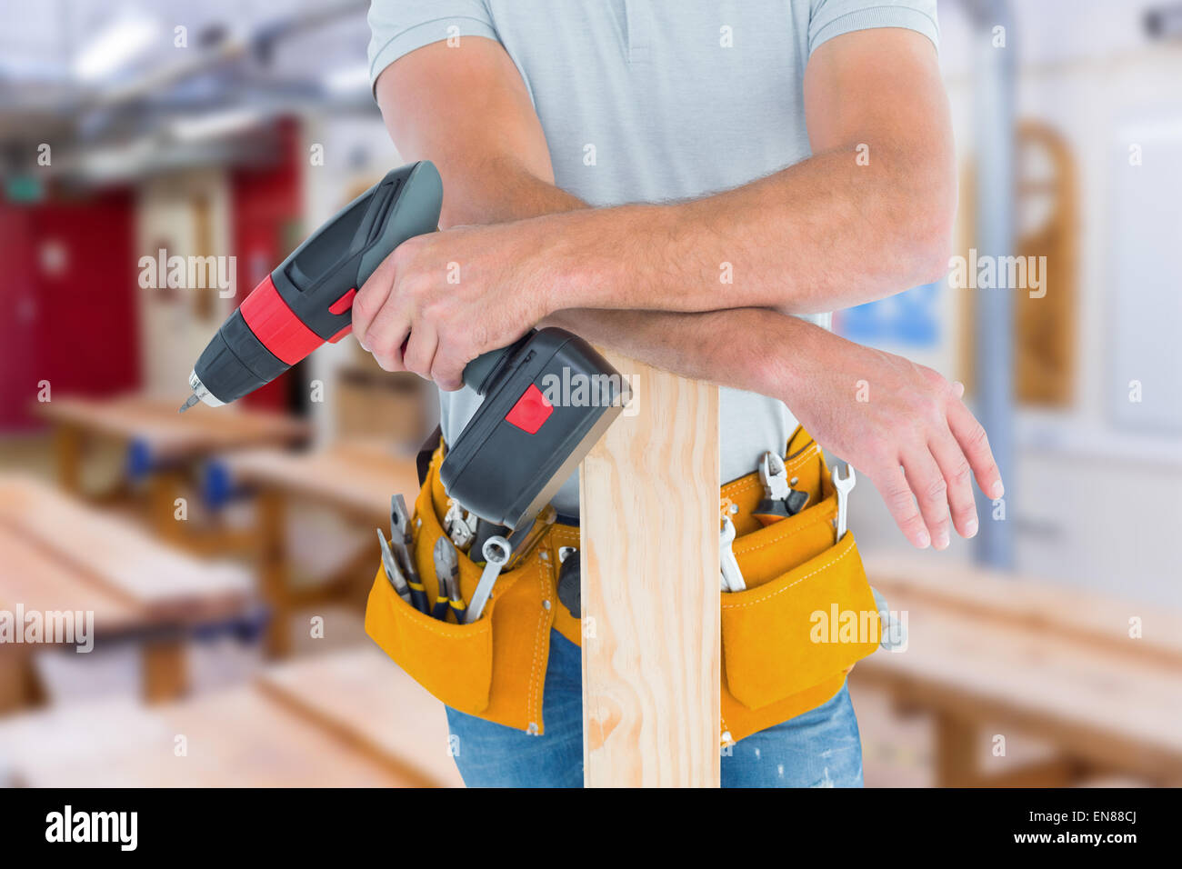 Composite image of midsection of male carpenter with power drill and plank Stock Photo