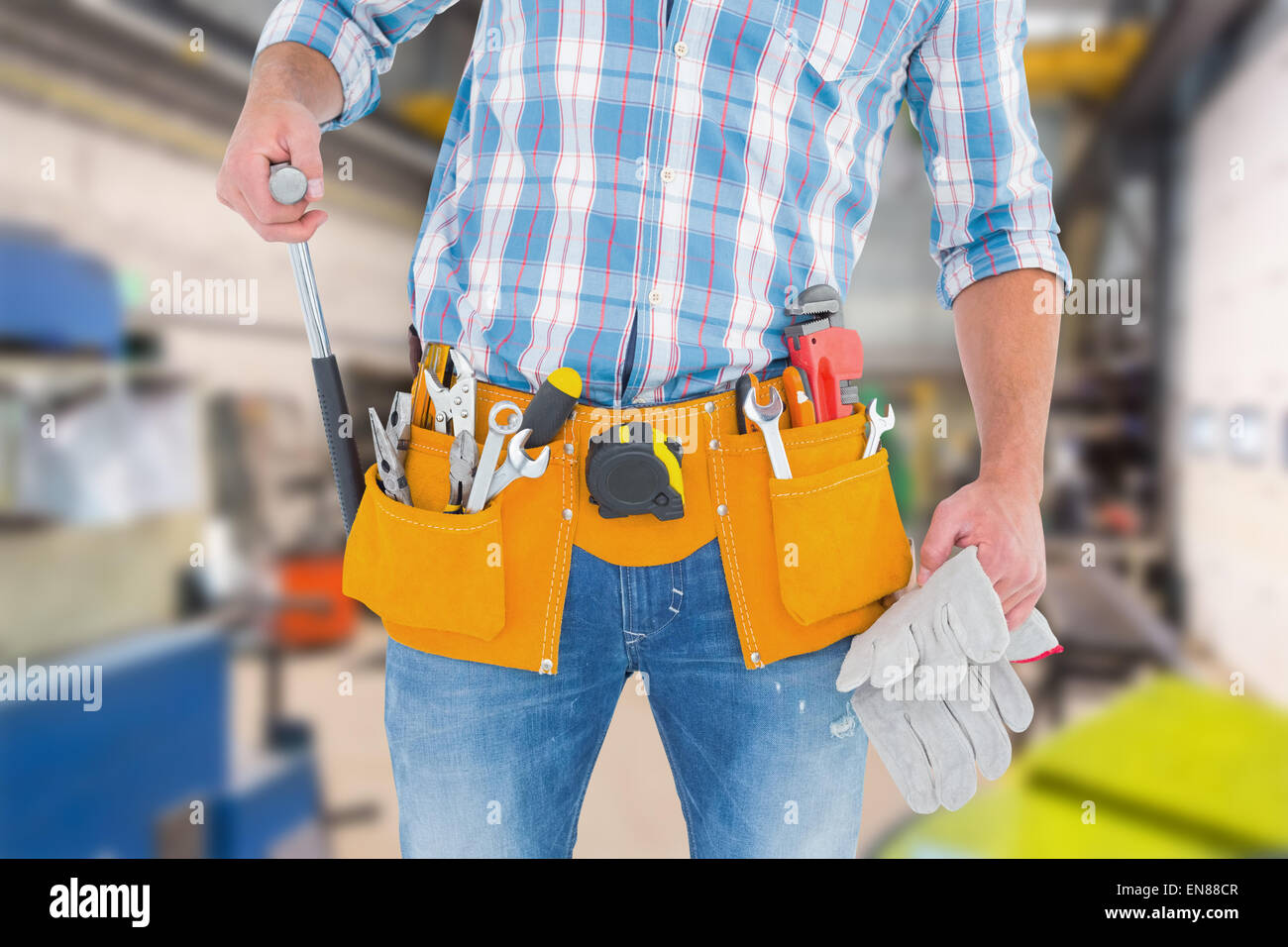 Composite image of midsection of handyman holding hammer and gloves Stock Photo