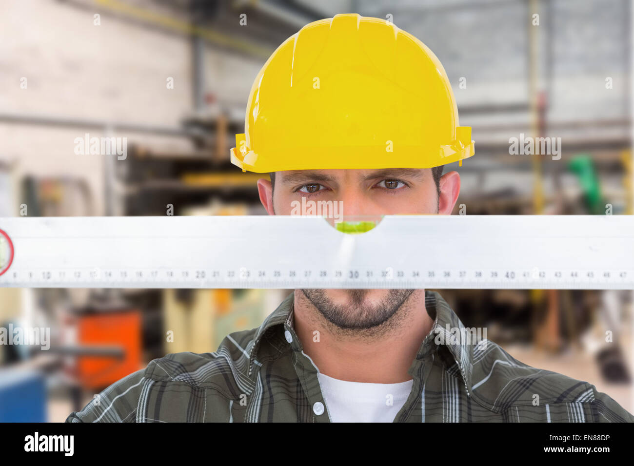 Composite image of handyman looking at spirit level Stock Photo