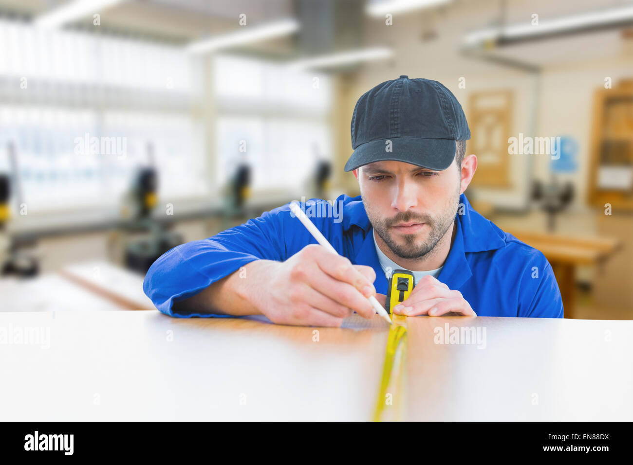 Composite image of worker measuring table Stock Photo