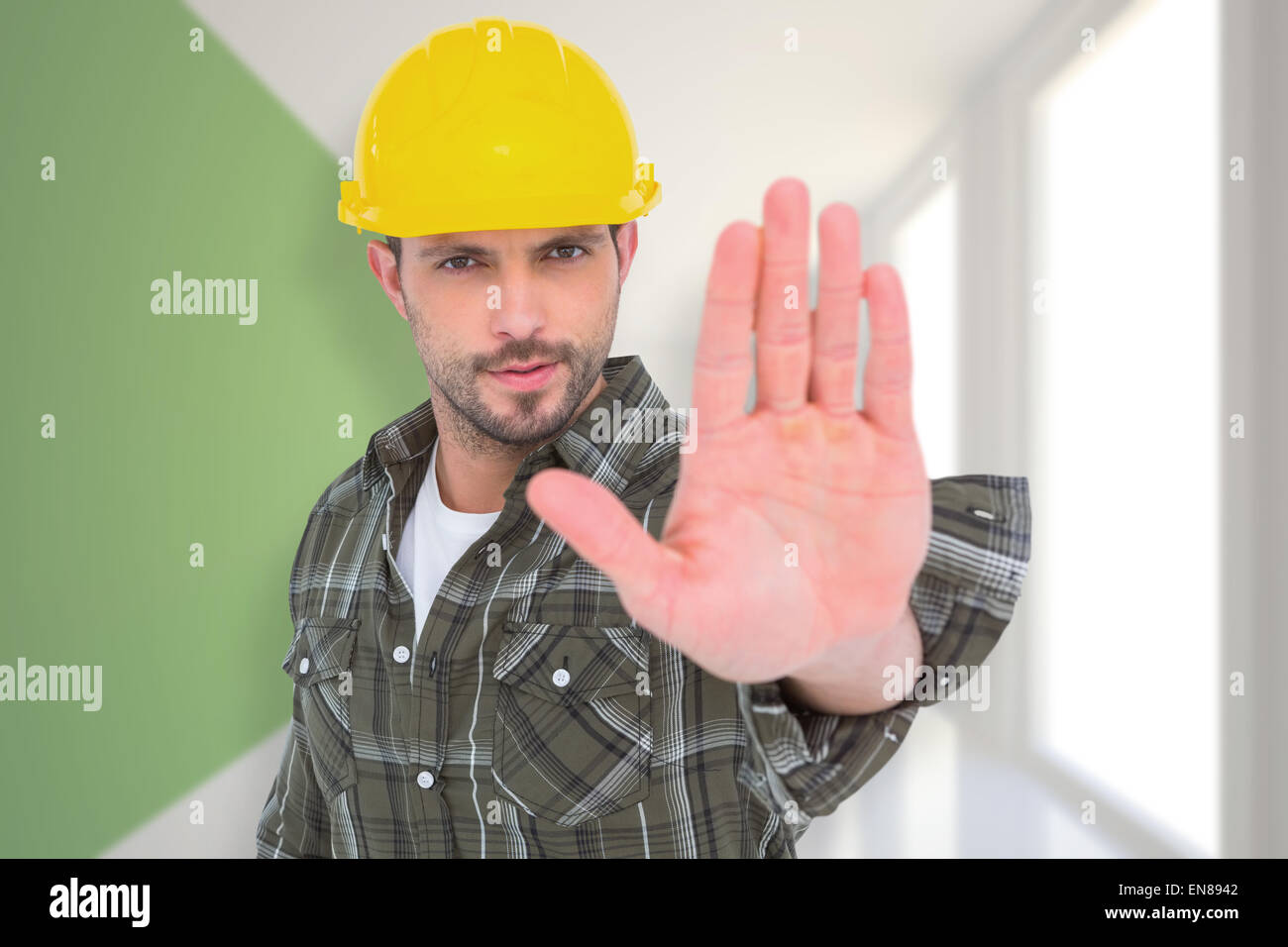 Composite image of confident manual worker gesturing stop sign Stock Photo
