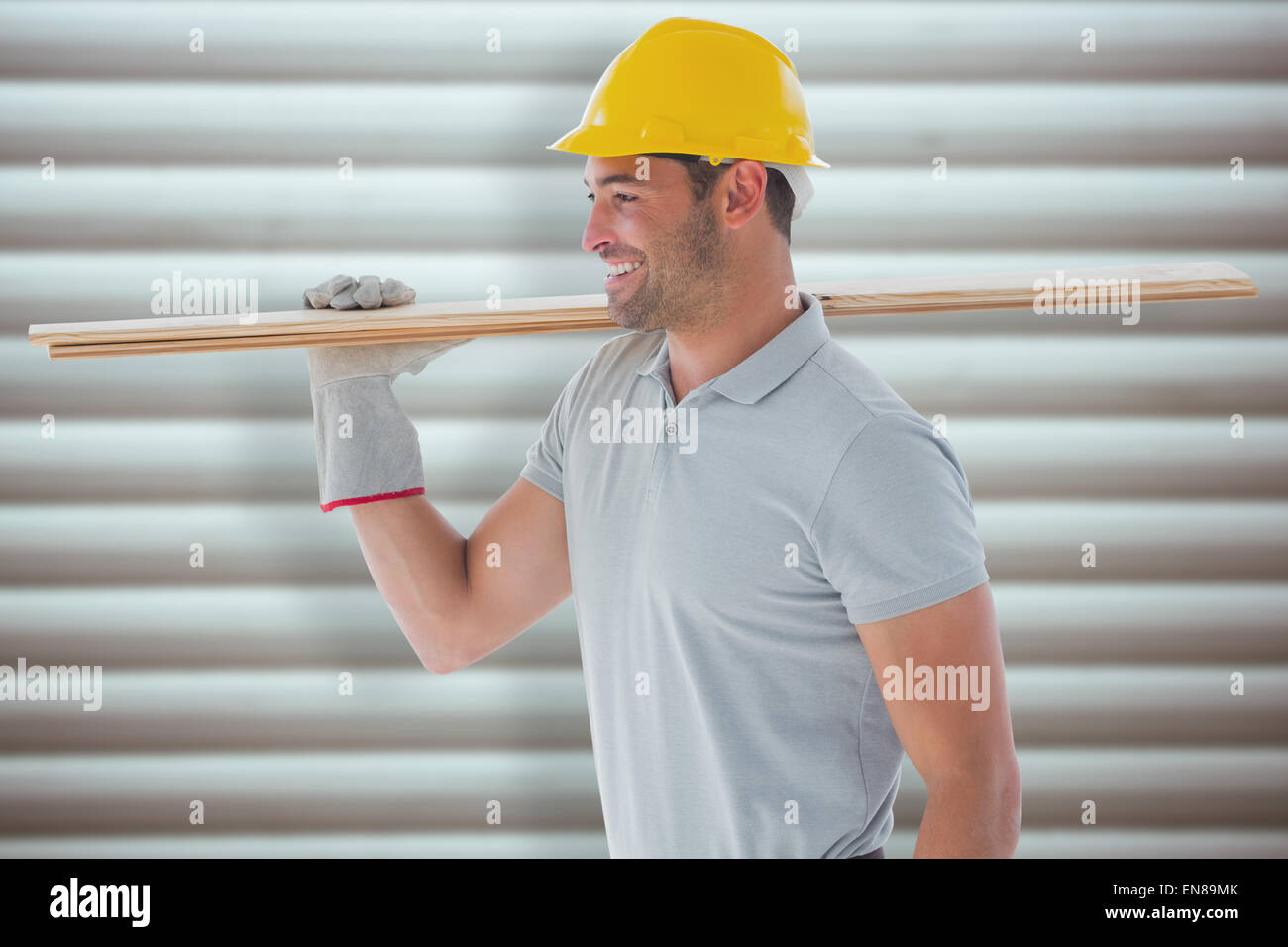 Composite image of worker with plank of wood Stock Photo