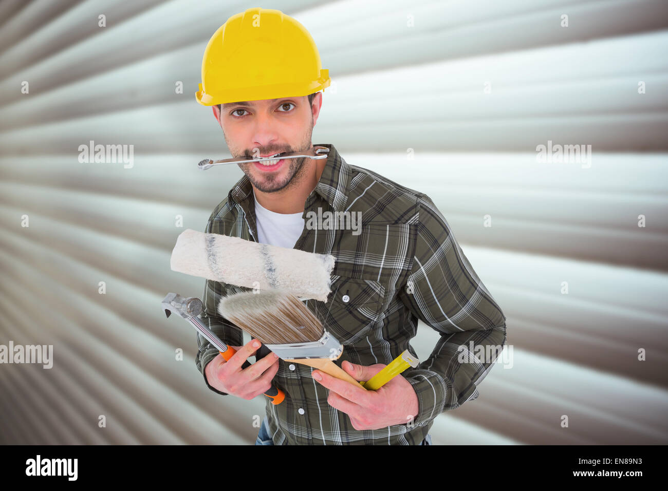 Composite image of manual worker holding various tools Stock Photo