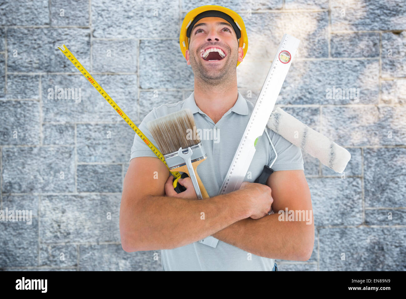 Composite image of laughing manual worker holding various tools Stock Photo