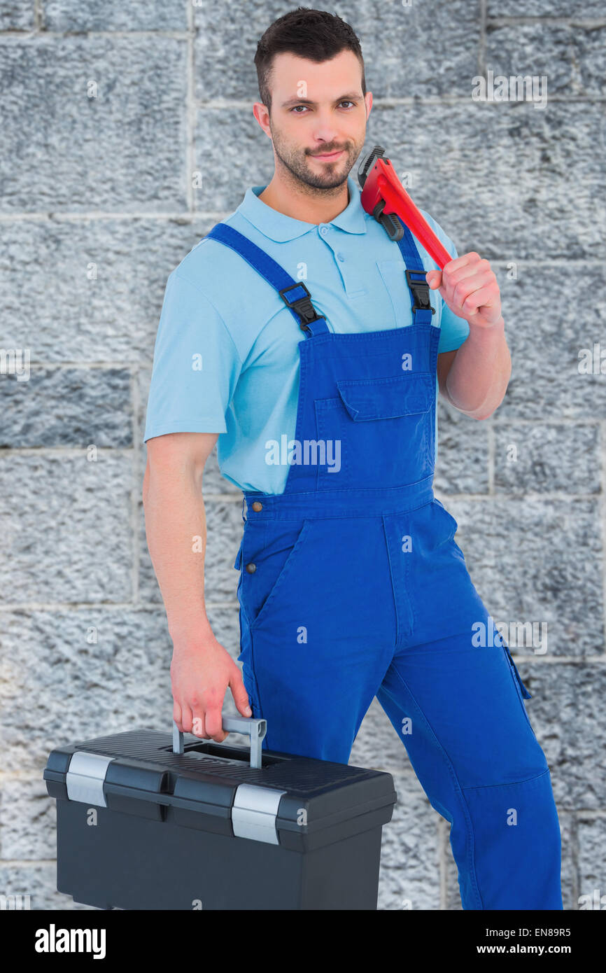 Composite image of repairman with toolbox and monkey wrench Stock Photo