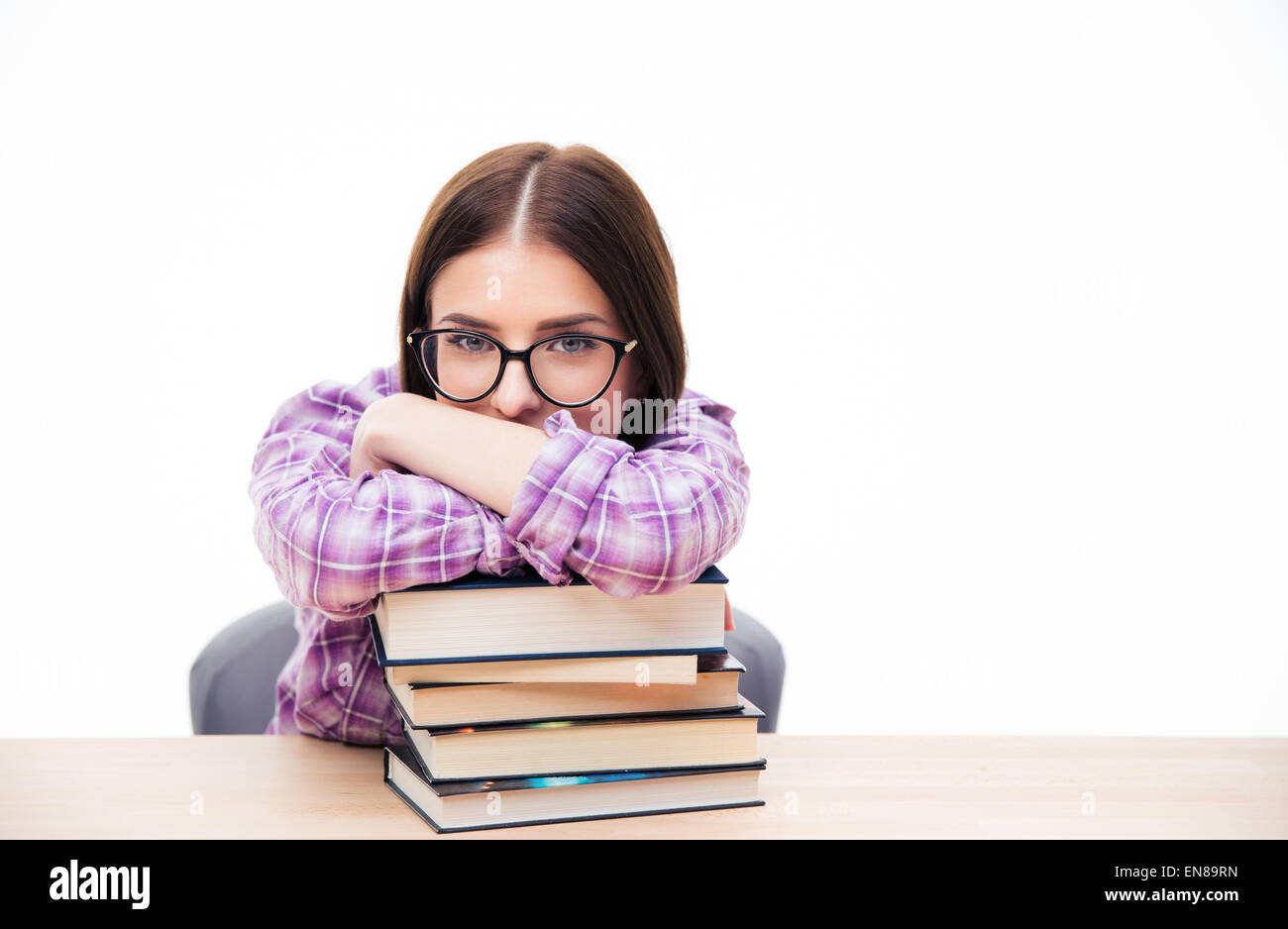 Young woman sitting at the table with books over white background and ...