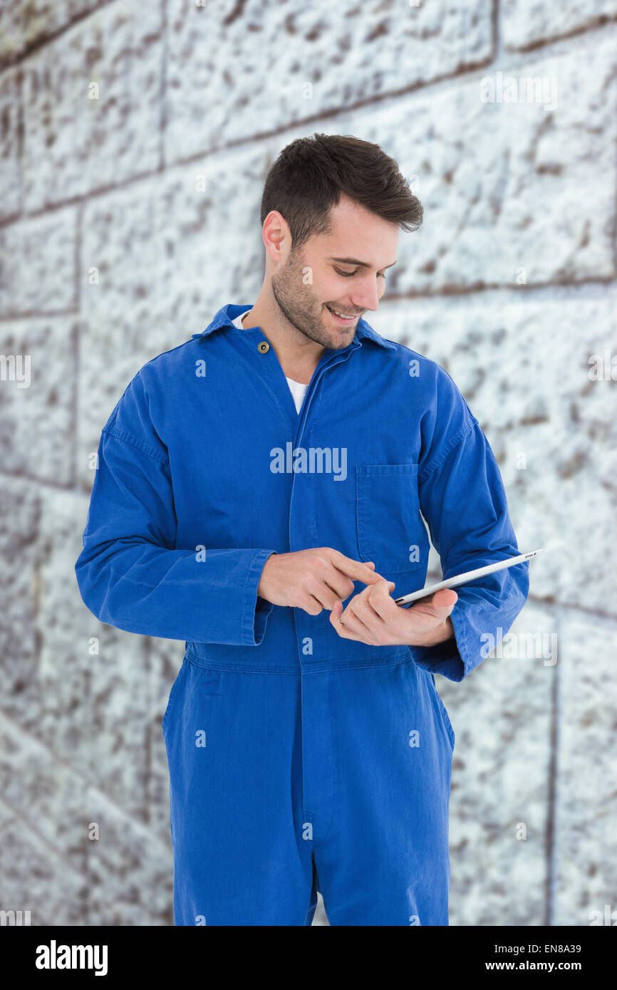 Composite image of male mechanic using digital tablet Stock Photo
