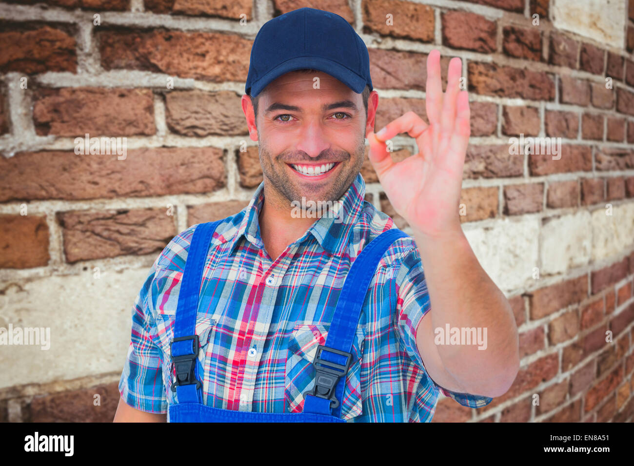 Composite image of portrait of smiling repairman gesturing okay Stock Photo