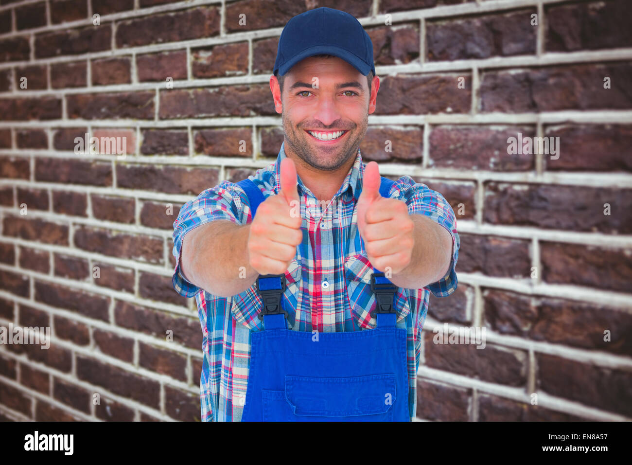Composite image of portrait of happy male repairman gesturing thumbs up Stock Photo