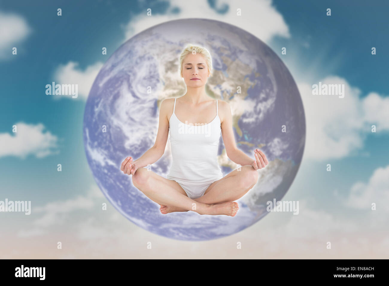 Composite image of toned young woman sitting in lotus pose with eyes closed Stock Photo