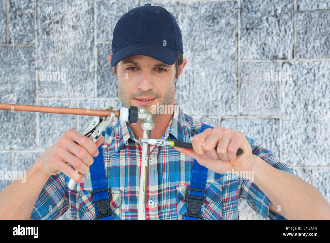Composite image of plumber fixing pipe over white background Stock Photo