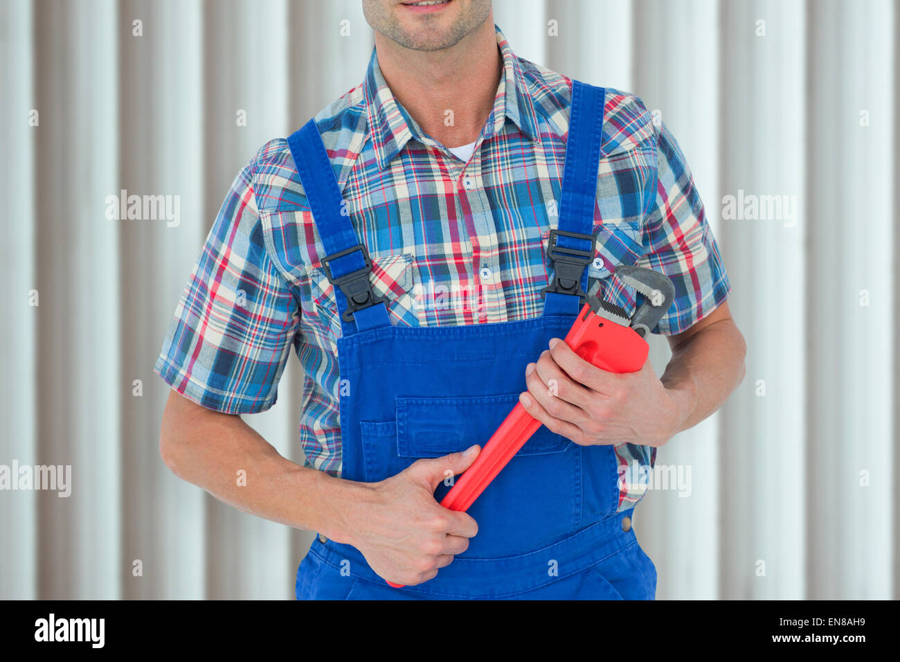 Composite image of cropped image of plumber holding monkey wrench Stock Photo