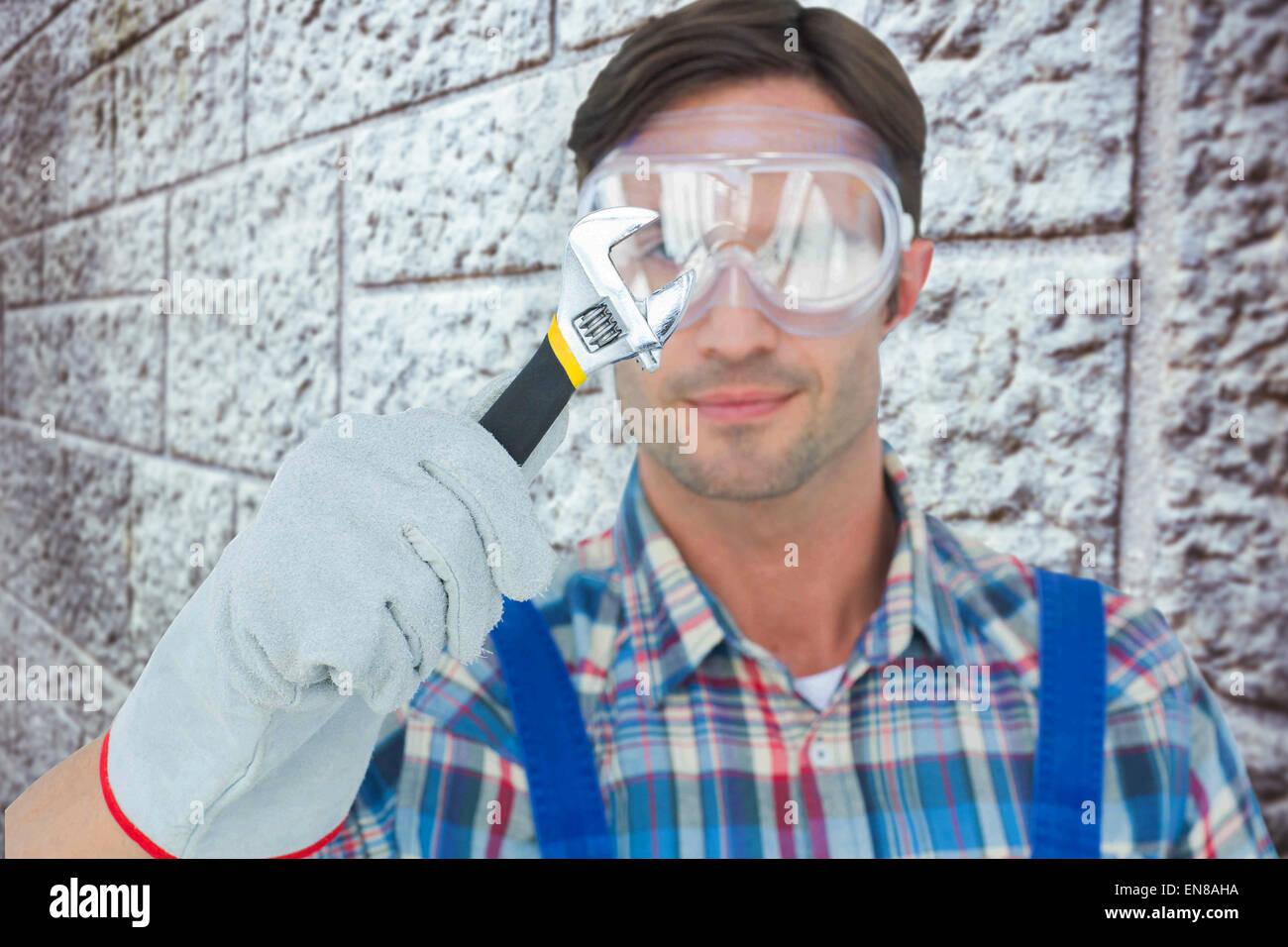 Composite image of plumber holding adjustable wrench Stock Photo