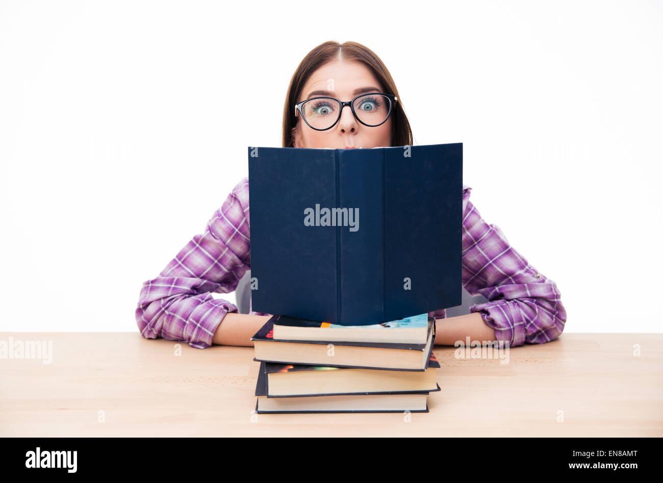Young woman sitting on the table with books over white background and ...